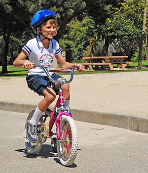 Niña en bicicleta con un casco.